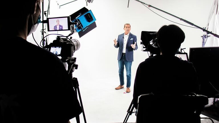 Behind the scenes on a presenter led studio shoot. Using a white background for a clean look.